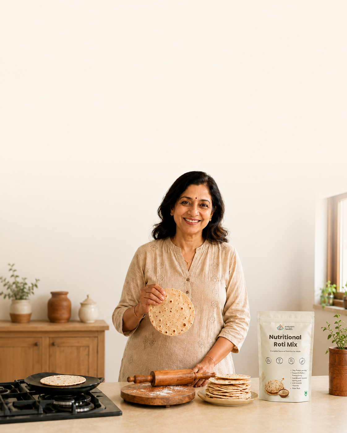 Healthy Indian woman around 60 holding a fresh roti in her kitchen with Svayam Nutritional Roti Mix